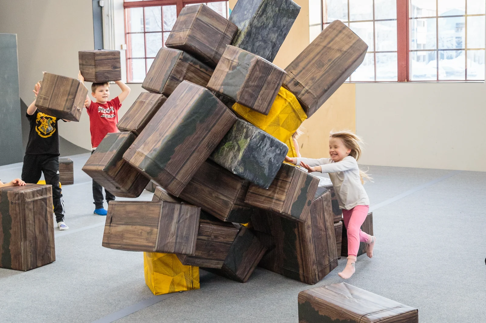 Children laughing and building together with foam blocks.